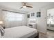 Bright bedroom featuring a ceiling fan, light wood flooring and a vanity with lighted mirror at 7715 Radcliffe Cir, Port Richey, FL 34668
