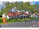 Community center has a red roof, mature trees, and ample parking at 7715 Radcliffe Cir, Port Richey, FL 34668