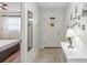 Bright hallway featuring neutral flooring, a decorative mirror, and a view into the adjacent bedroom at 7715 Radcliffe Cir, Port Richey, FL 34668