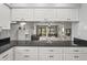 Open kitchen featuring granite countertops, white cabinets, and a view into the dining and living areas at 7715 Radcliffe Cir, Port Richey, FL 34668