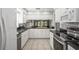 Well-lit kitchen boasts stainless appliances, granite counters, white cabinetry, and tile flooring at 7715 Radcliffe Cir, Port Richey, FL 34668