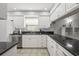 Updated kitchen with white cabinets, granite countertops, stainless steel appliances, and stylish tile backsplash at 7715 Radcliffe Cir, Port Richey, FL 34668