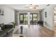 Inviting living room featuring wood-look floors, comfortable seating, and sliding glass doors to the outdoors at 7715 Radcliffe Cir, Port Richey, FL 34668