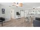 Bright living room with wood-look floors, modern decor, and open layout connecting to the kitchen at 7715 Radcliffe Cir, Port Richey, FL 34668
