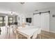 Bright living room with wood floors, sliding barn door closet, and access to the screened porch at 7715 Radcliffe Cir, Port Richey, FL 34668