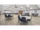A spacious meeting room features tables, chairs, ceiling fans, and neutral decor at 7715 Radcliffe Cir, Port Richey, FL 34668