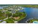 Scenic aerial view of a waterfront home featuring a private dock, lush landscaping, and a patio firepit at 8143 Channel Dr, Port Richey, FL 34668