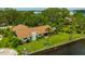 This waterfront home features lush green grass, an enclosed porch, and concrete reinforcement against water damage at 8143 Channel Dr, Port Richey, FL 34668