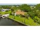 Waterfront home features a spacious yard with lush green grass, a private dock, and mature palm trees at 8143 Channel Dr, Port Richey, FL 34668