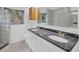 Bathroom vanity with double sinks, granite countertop, and backyard view at 8143 Channel Dr, Port Richey, FL 34668