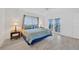 Bedroom with light hardwood floors, ceiling fan, and sliding glass doors to a balcony at 8143 Channel Dr, Port Richey, FL 34668