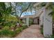 Home exterior featuring a brick walkway, well-kept landscaping, and a pergola-covered entrance at 8143 Channel Dr, Port Richey, FL 34668