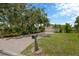 Inviting single-Gathering home features a brick driveway, mature trees, green grass, and well-manicured landscaping at 8143 Channel Dr, Port Richey, FL 34668