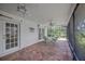 Screened patio with stone flooring, outdoor seating, and a fan at 8143 Channel Dr, Port Richey, FL 34668