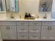 Spacious bathroom with dual sinks, white cabinetry, and modern gold hardware at 8209 Golf Club Ct, Hudson, FL 34667