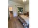 Bright bedroom with wood floors, large windows, and attached sunroom access at 8209 Golf Club Ct, Hudson, FL 34667