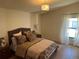 Comfortable bedroom features a woven headboard, neutral tones, and wood-look flooring at 8209 Golf Club Ct, Hudson, FL 34667