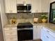 Bright kitchen with granite countertops, white cabinets, stainless steel appliances and a window overlooking greenery at 8209 Golf Club Ct, Hudson, FL 34667