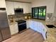 Well-lit kitchen with granite countertops, stainless steel appliances, and a window overlooking the backyard at 8209 Golf Club Ct, Hudson, FL 34667