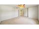 Bedroom featuring neutral carpet, ceiling fan, and an entranceway to another room at 8540 Caitlin Ct, Hudson, FL 34667
