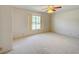 Bright bedroom featuring neutral carpet, a ceiling fan, and natural light from a large window at 8540 Caitlin Ct, Hudson, FL 34667