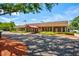 Community clubhouse featuring a red brick exterior with manicured landscaping and covered entrance at 8540 Caitlin Ct, Hudson, FL 34667