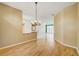 Dining room with hardwood floors and chandelier with views through large glass doors to backyard at 8540 Caitlin Ct, Hudson, FL 34667