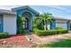 Inviting front entrance with arched doorway, mature landscaping, and a charming statue, exuding elegance at 8540 Caitlin Ct, Hudson, FL 34667