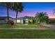 Charming single-story home with a lush green lawn and mature tropical landscaping, creating a welcoming curb appeal at 8540 Caitlin Ct, Hudson, FL 34667