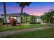 Charming single-story home with a lush green lawn and mature tropical landscaping, creating a welcoming curb appeal at 8540 Caitlin Ct, Hudson, FL 34667