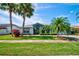 Charming single-story home with a lush green lawn and mature tropical landscaping, creating a welcoming curb appeal at 8540 Caitlin Ct, Hudson, FL 34667