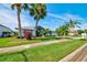 Charming single-story home with a lush green lawn and mature tropical landscaping, creating a welcoming curb appeal at 8540 Caitlin Ct, Hudson, FL 34667
