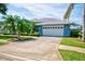 Spacious two-car garage with a well-manicured lawn and mature palm trees, offering ample parking at 8540 Caitlin Ct, Hudson, FL 34667