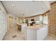 Bright kitchen featuring white cabinetry, a peninsula counter, and neutral tile flooring at 8540 Caitlin Ct, Hudson, FL 34667