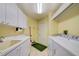 Bright laundry room with a utility sink, cabinets, and modern washer and dryer for efficient chores at 8540 Caitlin Ct, Hudson, FL 34667
