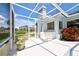 Screened patio with white tile, lounge chair, potted plants, and an outdoor sink at 8540 Caitlin Ct, Hudson, FL 34667