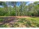 Outdoor playground area with swings, slide, and picnic table, perfect for Gathering fun in a wooded setting at 8540 Caitlin Ct, Hudson, FL 34667