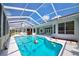 Enclosed pool with blue water, a fun beach ball, and a white tile surround at 8540 Caitlin Ct, Hudson, FL 34667