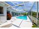 Refreshing pool area with screened enclosure, lounge chair, and colorful landscaping at 8540 Caitlin Ct, Hudson, FL 34667