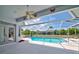 A view from the covered patio area out to the sparkling blue screened-in swimming pool at 8540 Caitlin Ct, Hudson, FL 34667