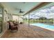 Relaxing screened lanai area with comfortable seating and views of the pool and lake at 8811 Napa Loop, New Port Richey, FL 34653