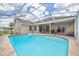 Relaxing outdoor pool area with a screened enclosure and patio space for lounging at 8811 Napa Loop, New Port Richey, FL 34653