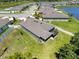 Aerial view of a single Gathering home featuring a screened lanai and a fenced yard next to a pond at 8855 Prairie Creek Dr, New Port Richey, FL 34655
