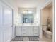 Bright bathroom featuring a double vanity, stylish mirrors, and a separate toilet area for added privacy at 8855 Prairie Creek Dr, New Port Richey, FL 34655