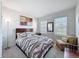 Cozy bedroom with a comfortable queen-sized bed, soft natural lighting, and a decorative sitting chair at 8855 Prairie Creek Dr, New Port Richey, FL 34655
