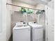 Functional laundry room with a full-size washer and dryer, plus practical shelving for storage at 8855 Prairie Creek Dr, New Port Richey, FL 34655