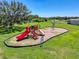 Community playground featuring a slide, swing set, and climbing structure near the lake at 8855 Prairie Creek Dr, New Port Richey, FL 34655