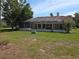 Spacious backyard features a screened-in lanai, lush green lawn, and mature landscaping at 9168 Southern Comfort Ct, Weeki Wachee, FL 34613