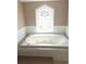 Large bathroom soaking tub with decorative window providing natural light at 9168 Southern Comfort Ct, Weeki Wachee, FL 34613
