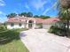 Inviting home featuring a well-manicured lawn, beautiful landscaping, and an attached two car garage at 9168 Southern Comfort Ct, Weeki Wachee, FL 34613